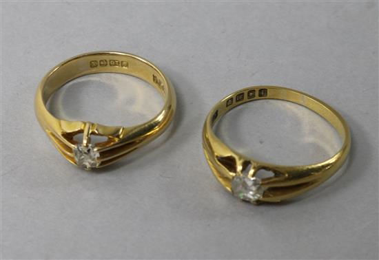 Two early 20th century 18ct gold and claw set solitaire diamond rings, sizes P & T.